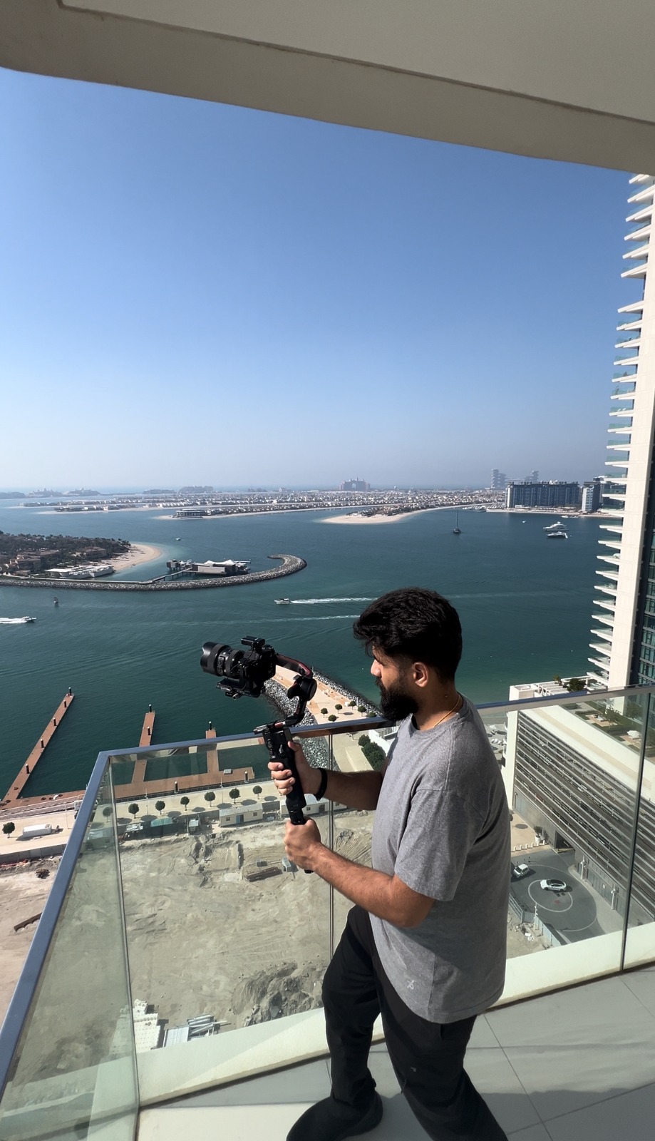 Priyesh Thakur, freelance content creator in Dubai, filming on a gimbal overlooking Palm Jumeirah